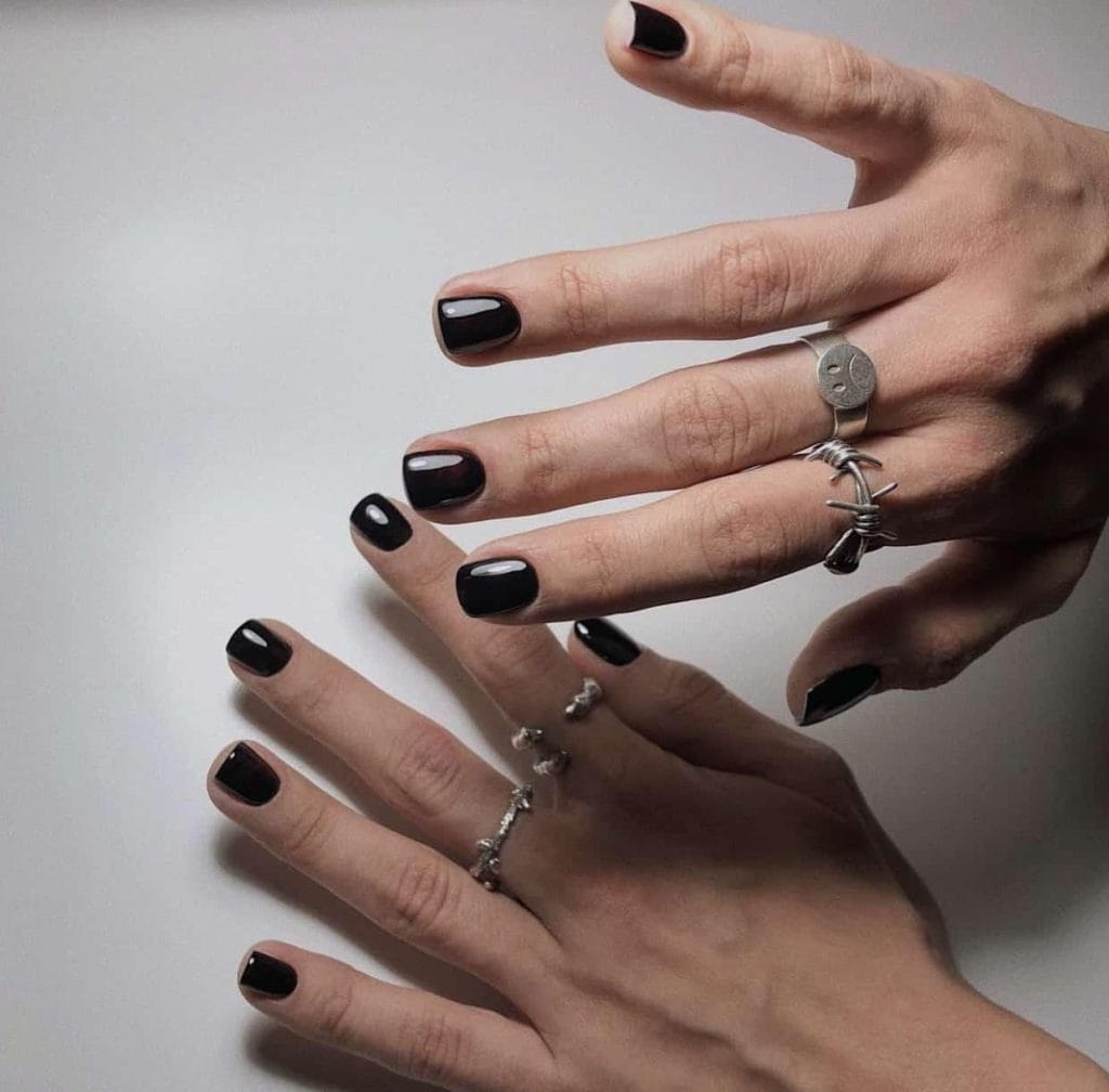 A woman wearing black nail polish after getting a Russian manicure in Oakville.