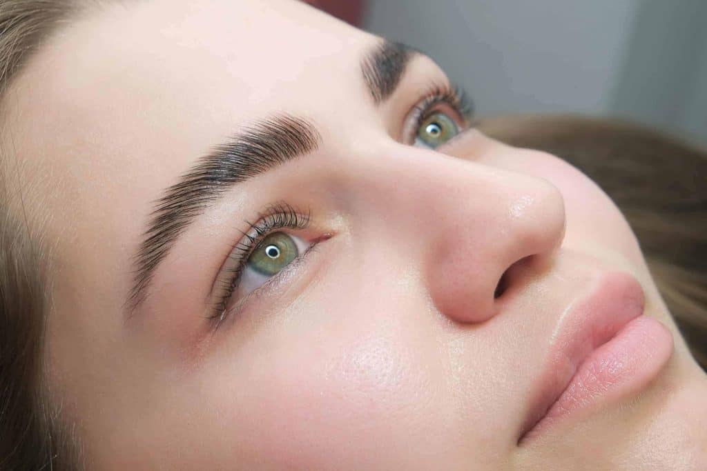 Close-up of professionally laminated eyebrows, showing full and defined brow shape